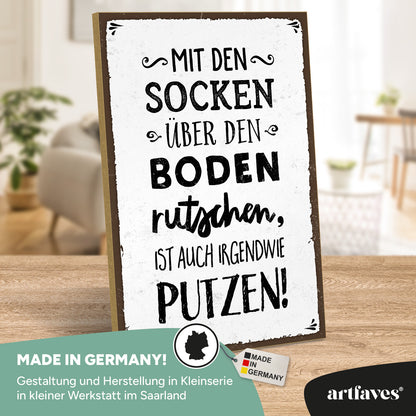 schild-mit-spruch-mit-socken-ueber-den-boden-rutschen
